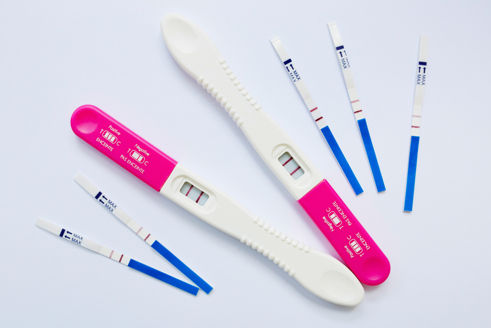 Glass of Urine and Pregnancy Test and Test Strips Stock Photo